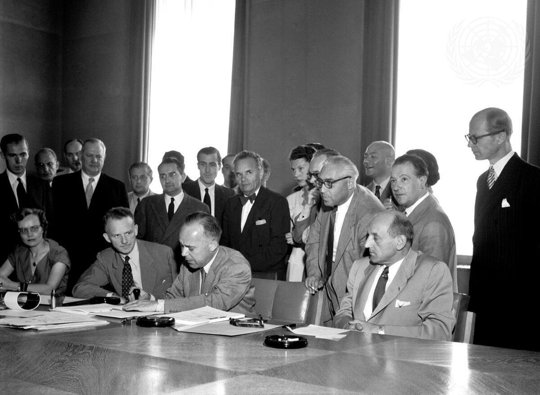 Group of officials signing a the 1951 UN Refugee Convention
