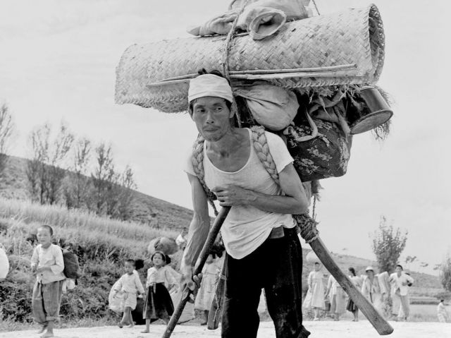 Korean refugee with large burden on his back.