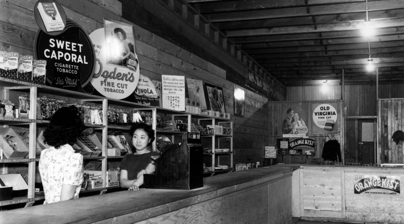 Women standing behind counter in a restaurant or store.